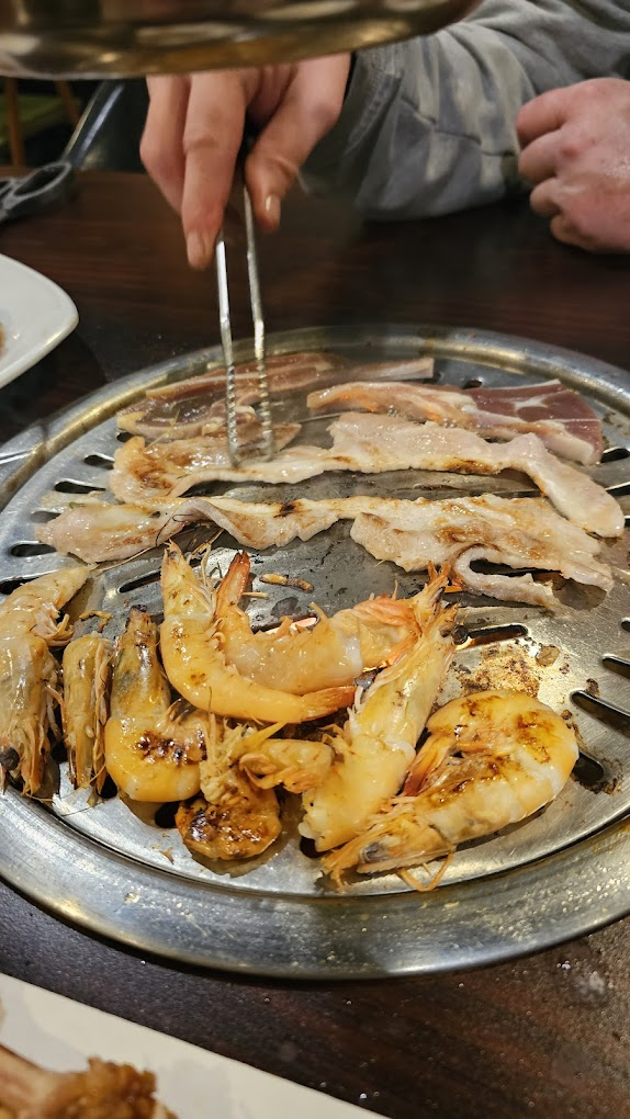 Tongs grilling Korean BBQ meat